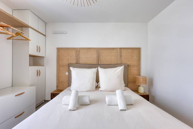 Chambre haut de gamme avec tête de lit en bois et literie blanche – Location courte durée à Cannes, Côte d'Azur